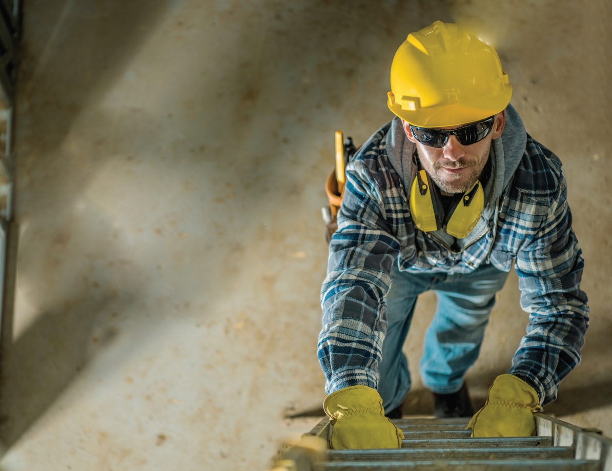 Homme au travail qui monte sur une échelle