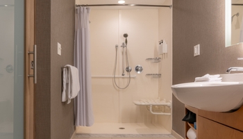 Douche PMR à l'italienne avec siège et barre d'appui